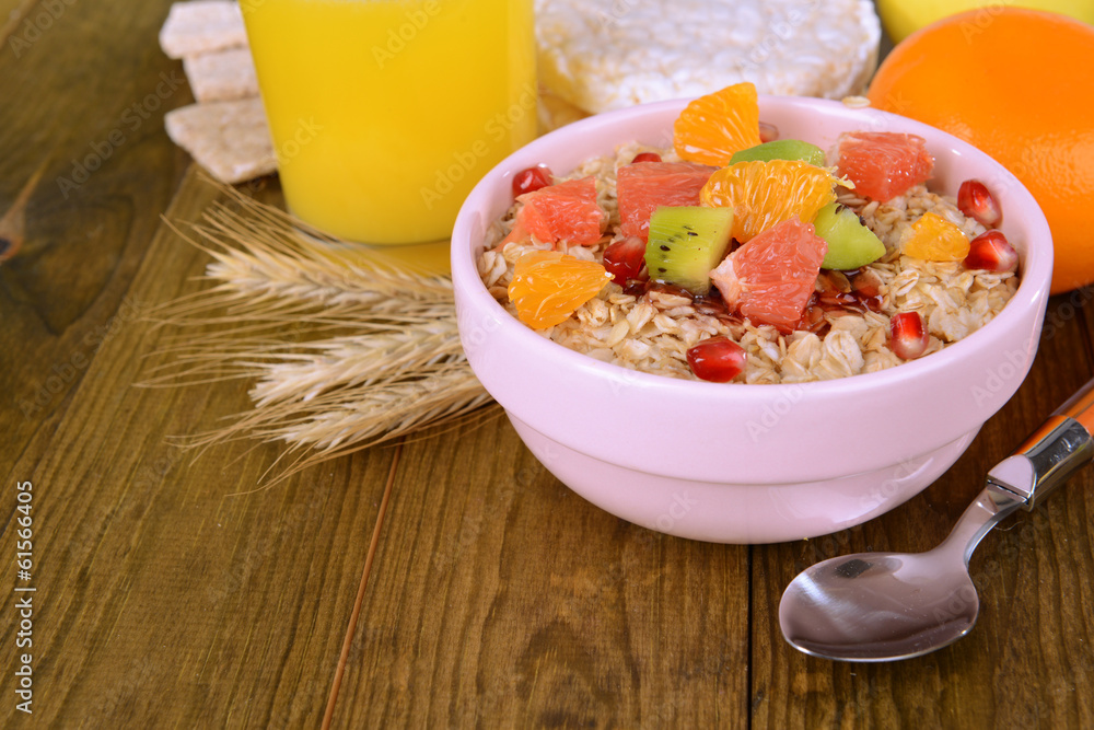 Delicious oatmeal with fruit in bowl on table close-up