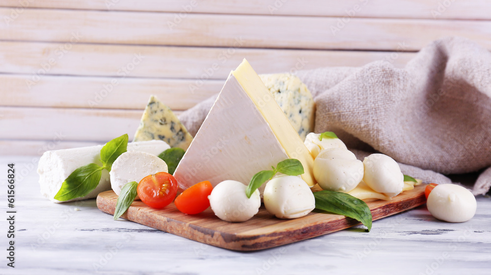 Different tasty cheese, on wooden table
