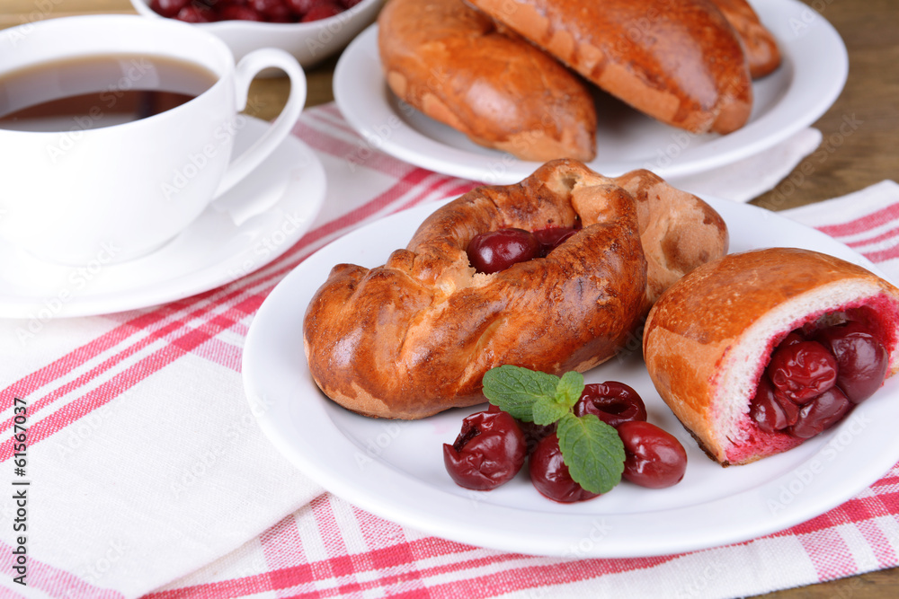 Fresh baked pasties with cherry on plate on table close-up