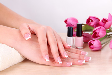 Wall Mural - Beautiful woman hands with french manicure and flowers