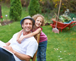 Tochter umarmt Vater im Garten