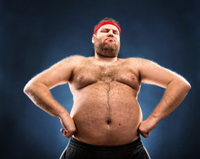 Fat Man Imitating Muscular Build. Low Angle View