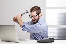Furious Businessman Destroying His Laptop With A Hammer..