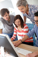 Teacher with students working on desktop