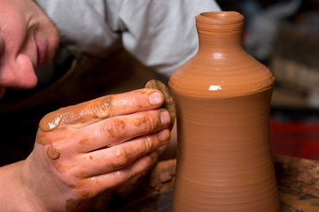 hands of a potter, creating an earthen jar