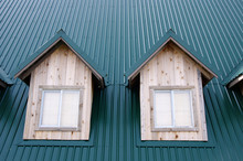Two Dormer With Windows On The Green Roof
