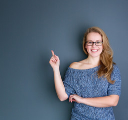 Smiling young woman pointing finger