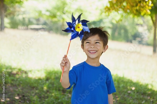 Fotografia, Obraz Happy cute little boy holding pinwheel at park