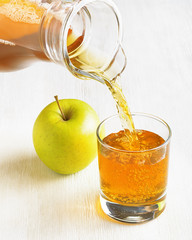 Canvas Print - Apple juice pouring from jug into a glass