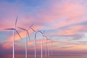 Wind generators turbines in the sea on sunset