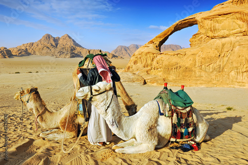 Fotografia, Obraz Bedouin man and his camels in the desert of Wadi Rum