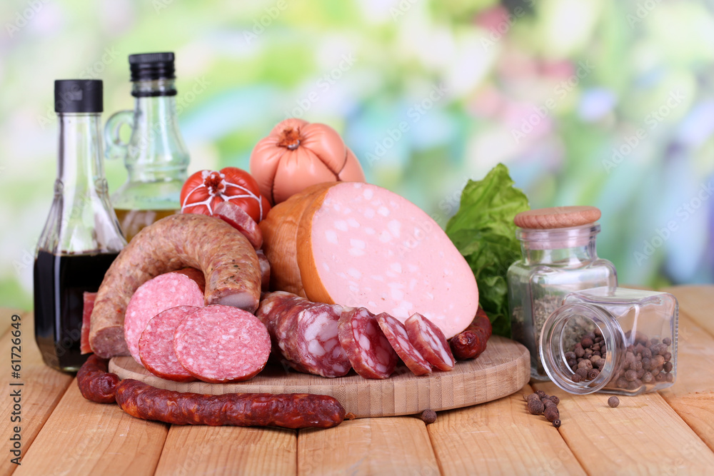 Different sausages on wooden table on natural background