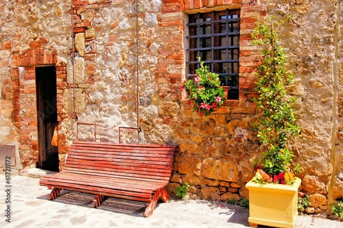 Board z aluminiowym obramowaniem Ławka wzdłuż średniowiecznego kamienia domu w Tuscany, Italy