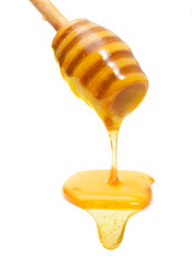 Honey drip from wooden dipper isolated on white background