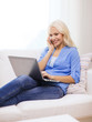 © Syda Productions - smiling woman with smartphone and laptop at home