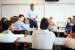 © Monkey Business - Male Tutor Teaching University Students In Classroom