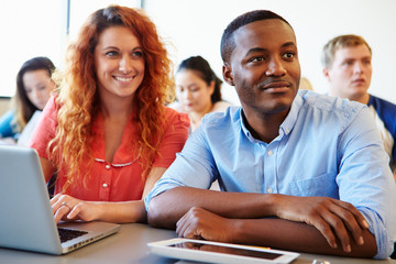 Wall Mural - university students using digital tablet and laptop in class