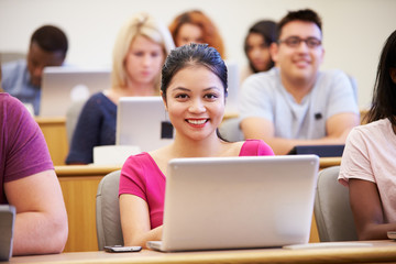 Wall Mural - female university student using laptop in lecture