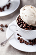 Coffee beans in a white cup with coffee merengue on top