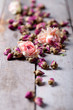 Dried rose buds scattered on a wooden table