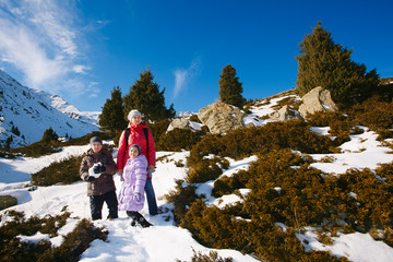 Wall Mural - Family (mother with two children) take a walk on winter mountain