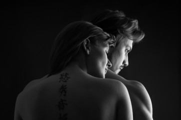 Wall Mural - Young couple close up intimate studio portrait in a romantic moo