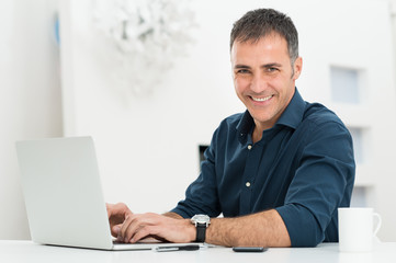 Man Using Laptop At Desk