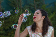 © Fernando Cortés - a beautiful woman blowing bubbles. spring season, rural scene