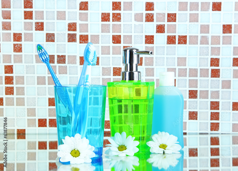 Cosmetics and bath accessories on mosaic tiles background