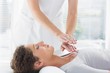 © WavebreakMediaMicro - Therapist performing Reiki over woman