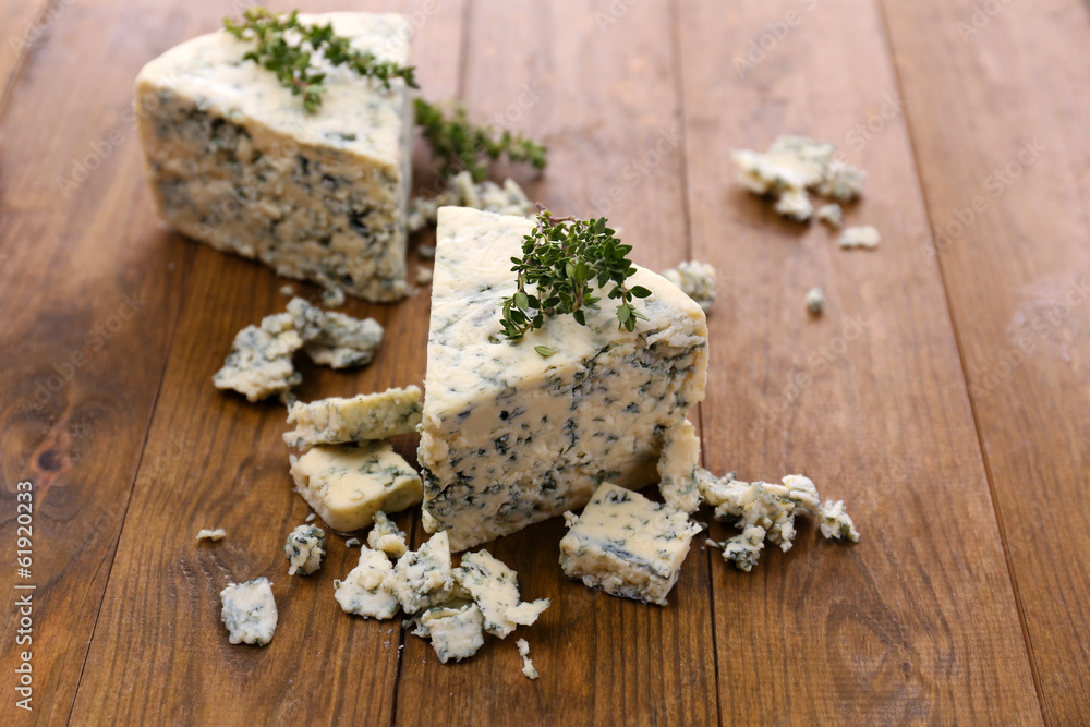 Tasty blue cheese with thyme, on wooden table