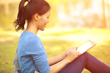 Wall Mural - college student sit on grass with digital tablet