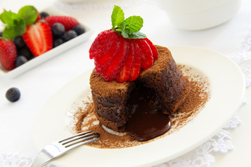 Wall Mural - Chocolate dessert fondant with a liquid center and strawberries.