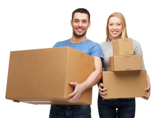 smiling couple holding cardboard boxes