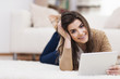 © gpointstudio - Beautiful woman lying on carpet and using digital tablet .