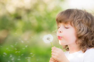 Canvas Print - Happy child blowing dandelion