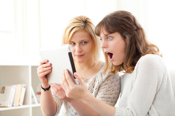 Girls learning important news reading on tablet