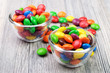 Two bowls with candies and some scattered around