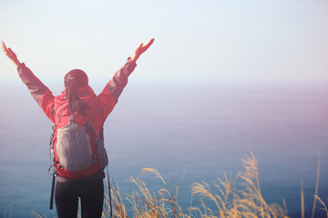 cheering woman hiker open arms seaside mountain peak