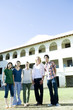 © TAGSTOCK2 - smiling students in front of school building.