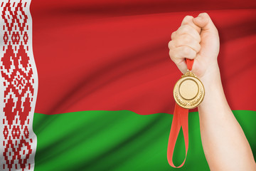 Medal in hand with flag on background - Republic of Belarus