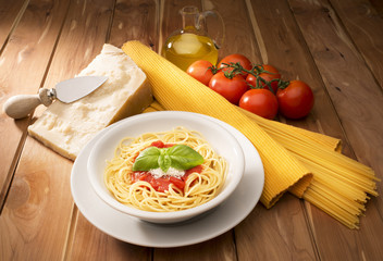 dish with spaghetti and tomato sauce on the wooden table