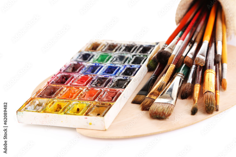 Many brushes on wooden palette, isolated on white