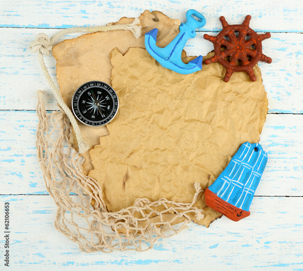 Old paper with sea accessories, isolated on wooden background