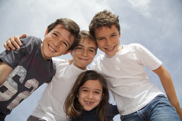 Grupo de niños cogidos por los hombros sonriendo