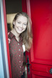 © jackfrog - beautiful young woman opening a red door to welcome someone