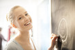 © jackfrog - beautiful young woman drawing a smiley face on a blackboard at h