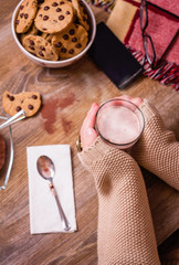 Wall Mural - Female hands with hot drink and chocolate cookies