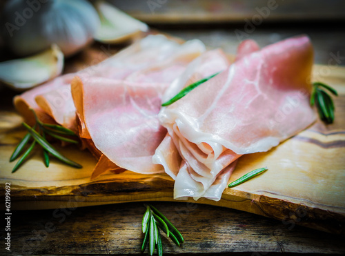 Board z aluminiowym obramowaniem Prosciutto z czosnkiem i rozmarynem na rustykalne drewniane tła