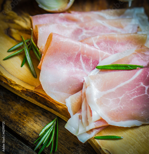 Board z aluminiowym obramowaniem Prosciutto z czosnkiem i rozmarynem na rustykalne drewniane tła